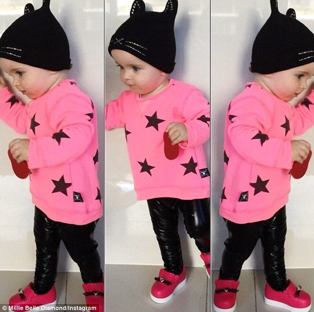 'When ur a big girl now and u can stand for ur photos (working on the look at camera and don't run away thing and we may be holding some wooden meat but it's a start,' Ms Fox laughed at these photos of Millie-Belle